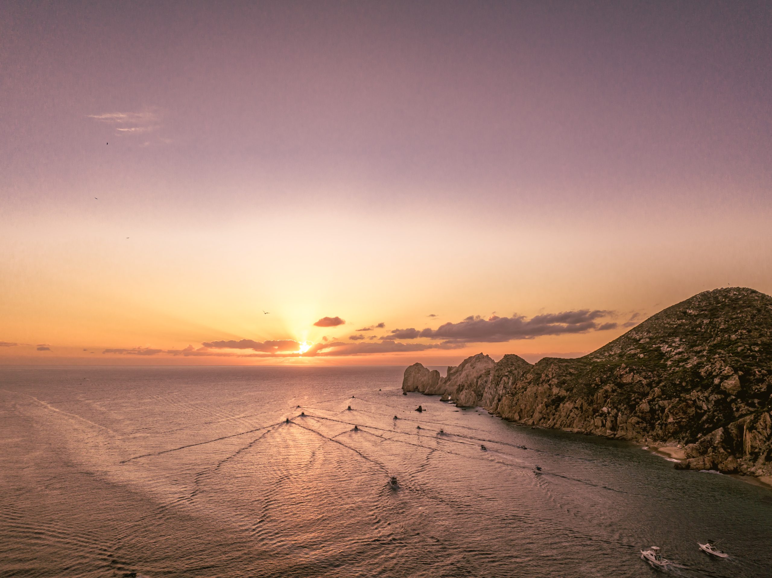 sunset over the ocean in cabo